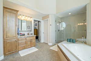 Bathroom featuring a stall shower, vanity, a bath, and light colored carpet