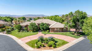 Mediterranean / spanish home with stone siding, a tiled roof, a mountain view, and a front lawn