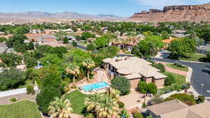 Aerial perspective of suburban area with a mountainous background and a pool