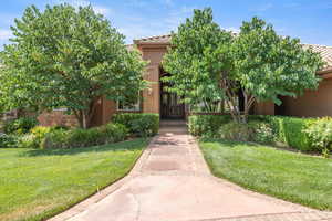 View of front of home with a tile roof, stucco siding, and a front lawn