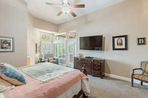 Bedroom featuring access to outside, light colored carpet, ceiling fan, and a towering ceiling