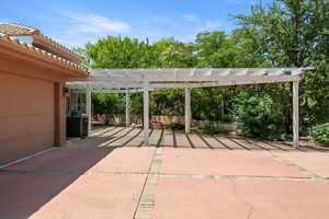 View of patio / terrace featuring a pergola and a garage