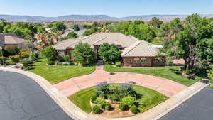 Mediterranean / spanish-style home with a tiled roof, a front lawn, a mountain view, and stone siding