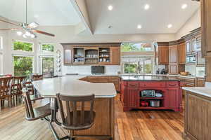 Kitchen with open shelves, tasteful backsplash, high vaulted ceiling, a kitchen bar, and recessed lighting