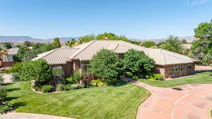 Mediterranean / spanish-style house with stone siding, a front yard, and a chimney