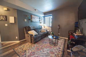 Living room featuring wood finished floors and a textured ceiling