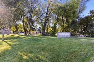 View of property's community featuring a yard and view of wooded area