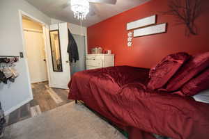 Bedroom featuring wood finished floors, ceiling fan, and a textured ceiling