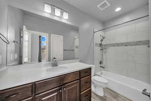 Bathroom featuring bathing tub / shower combination, vanity, light wood finished floors, and recessed lighting