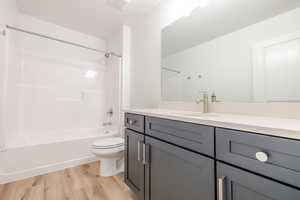 Full bathroom with vanity, light wood-type flooring, and bathing tub / shower combination