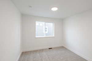 Empty room with light carpet and baseboards