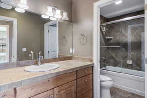 Full bath featuring vanity and combined bath / shower with glass door