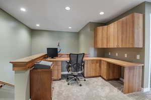 Home office with light colored carpet, recessed lighting, and built in study area