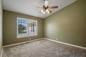 Unfurnished room with vaulted ceiling, carpet floors, and ceiling fan