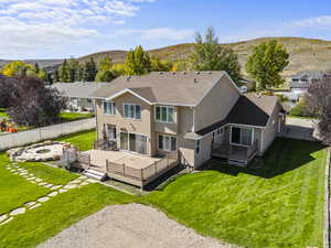 Back of house with a deck with mountain view, a shingled roof, stucco siding, and a fire pit
