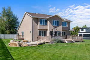 Rear view of property with stucco siding and a deck