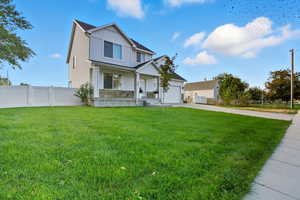 View of front facade with board and batten siding, stone siding, concrete driveway, a gate, and a porch