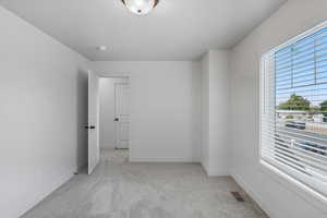 Empty room featuring light carpet and baseboards