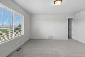 Unfurnished room with light colored carpet and baseboards