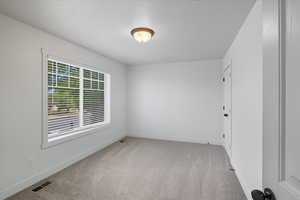 Spare room featuring light carpet and baseboards