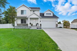 View of front of property with stone siding, a garage, board and batten siding, and concrete driveway