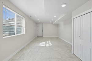 Unfurnished bedroom with recessed lighting, a closet, and light tile patterned flooring