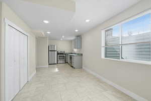 Kitchen with gray cabinets, appliances with stainless steel finishes, recessed lighting, light tile patterned floors, and light countertops