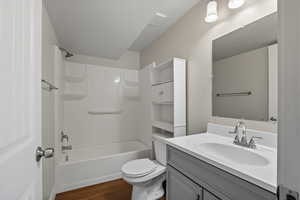 Bathroom with shower / washtub combination, vanity, and dark wood-style floors