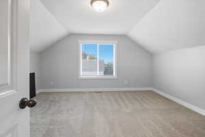 Bonus room with light carpet and lofted ceiling