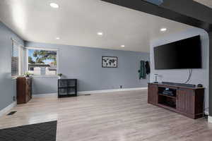Living area featuring light wood-style floors and recessed lighting