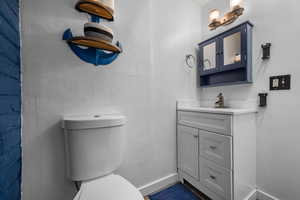 Half bathroom with vanity and a textured wall