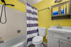 Bathroom featuring shower / tub combo with curtain and vanity