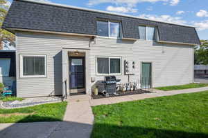 View of front of property featuring roof with shingles, mansard roof, and a front yard