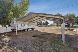 View of car parking with a detached carport and a gate