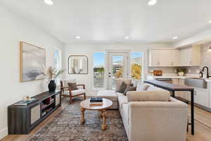 Living area with healthy amount of natural light, light wood finished floors, and recessed lighting