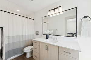 Full bath featuring dark wood-type flooring, vanity, recessed lighting, and a shower with shower curtain