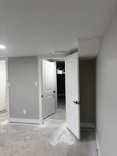 Finished below grade area with baseboards and a textured ceiling