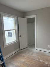 Unfurnished bedroom featuring wood-type flooring and a closet