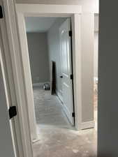 Corridor featuring a textured wall and baseboards