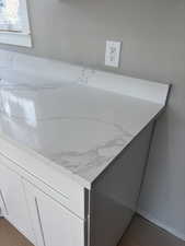 Detailed view of light stone counters and white cabinets