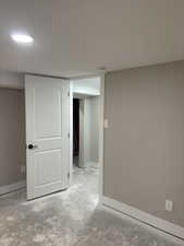 Finished basement with baseboards and a textured ceiling