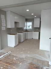 Kitchen with white cabinetry and recessed lighting