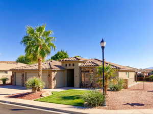 Mediterranean / Spanish-style house with stucco & stone exterior, wide driveway & 3-car garage, and RV parking w/ full utility hookups