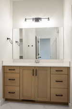 Bathroom with vanity, a closet, and light marble finish floors