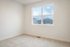 Empty room with light colored carpet and baseboards