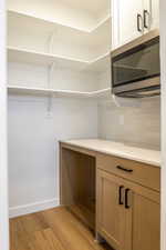 Walk in closet with light wood-type flooring