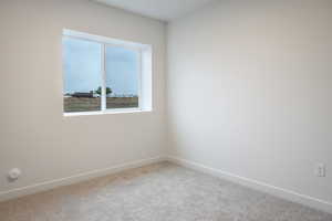 Carpeted spare room with baseboards