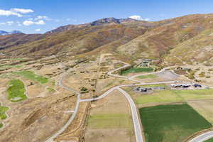 Aerial view of property and surrounding area featuring mountains and rural landscape