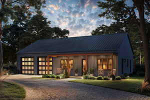 View of front of property featuring a porch, driveway, a metal roof, and a front lawn