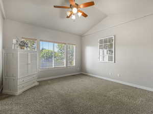 Unfurnished bedroom with lofted ceiling, carpet floors, and ceiling fan
